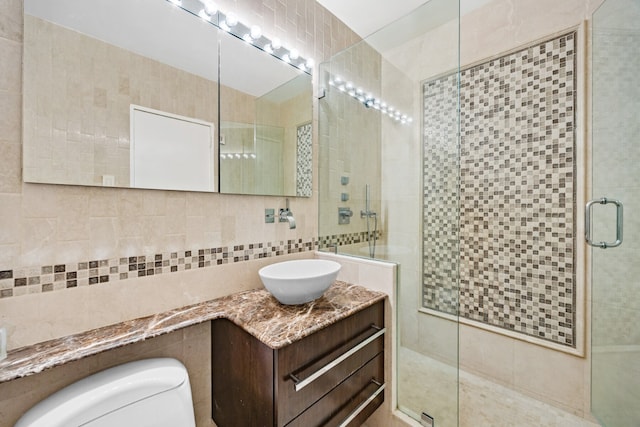 75 E End Ave Unit 19C, New York City, NY 10028 - bathroom featuring tile walls, toilet, a stall shower, and vanity