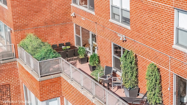 view of side of home featuring a balcony and brick siding