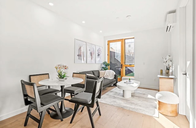 dining room featuring a wall mounted AC, light wood-type flooring, baseboards, and recessed lighting