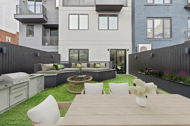 exterior space with outdoor dining space, a balcony, a fenced backyard, grilling area, and outdoor lounge area