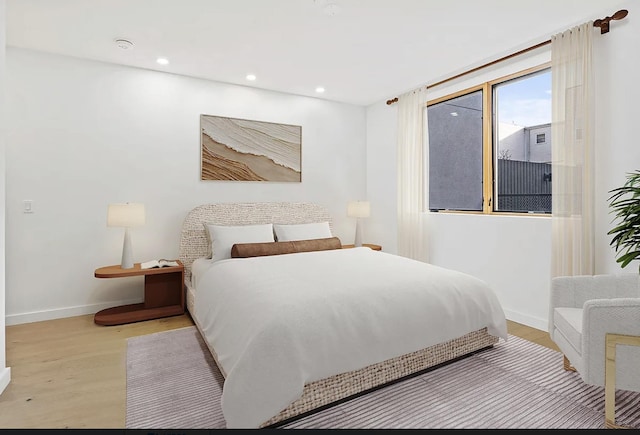 bedroom with light wood finished floors, recessed lighting, and baseboards