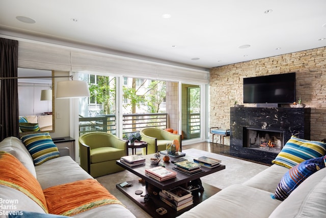 living room featuring a premium fireplace and wood finished floors