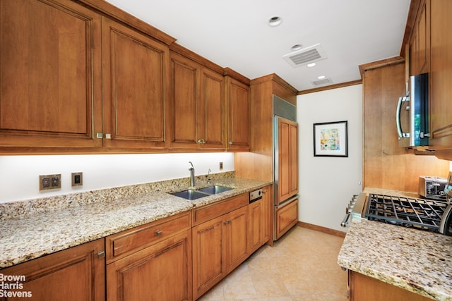 kitchen featuring a sink, visible vents, range, brown cabinetry, and stainless steel microwave