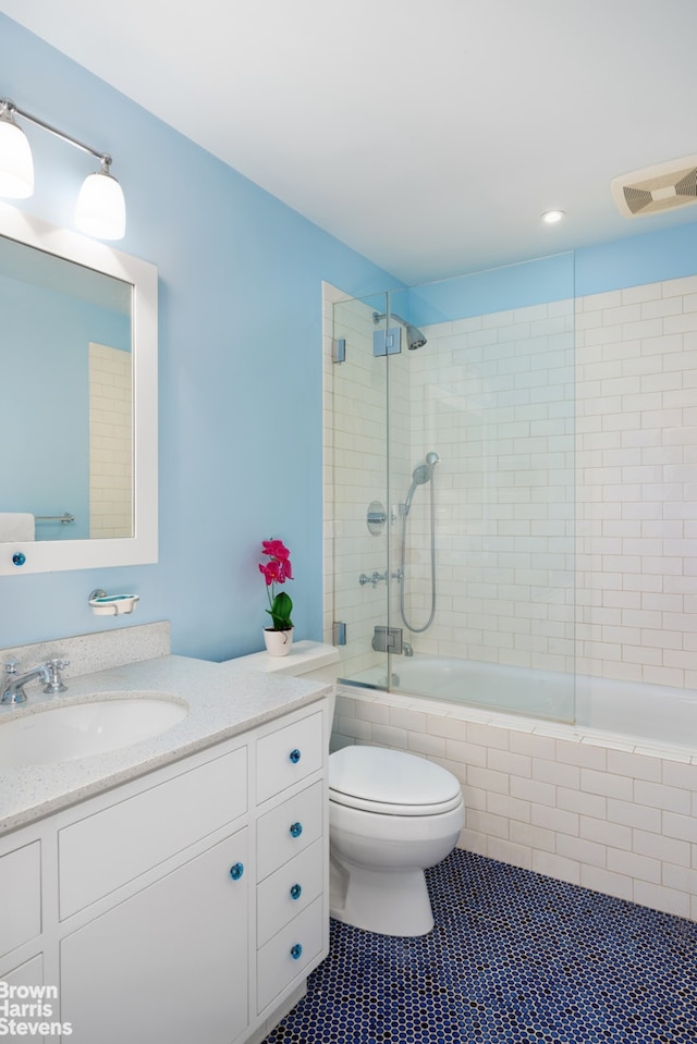 full bathroom with visible vents, toilet, tile patterned flooring, tiled shower / bath, and vanity