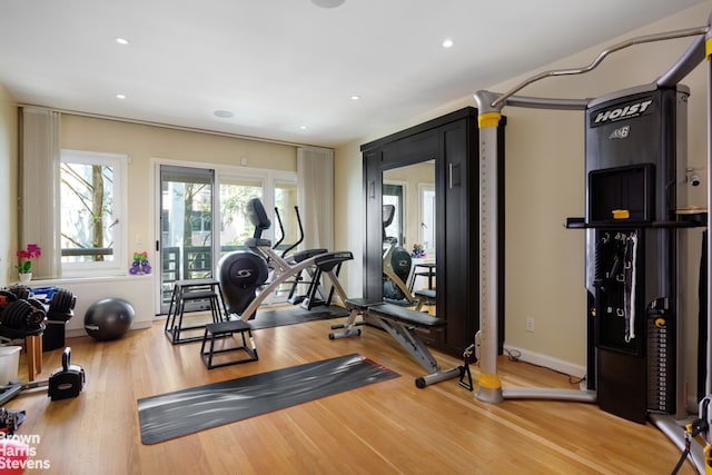 exercise room with baseboards, wood finished floors, and recessed lighting