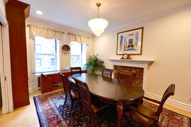 dining area featuring baseboards, light wood-style floors, an inviting chandelier, and crown molding