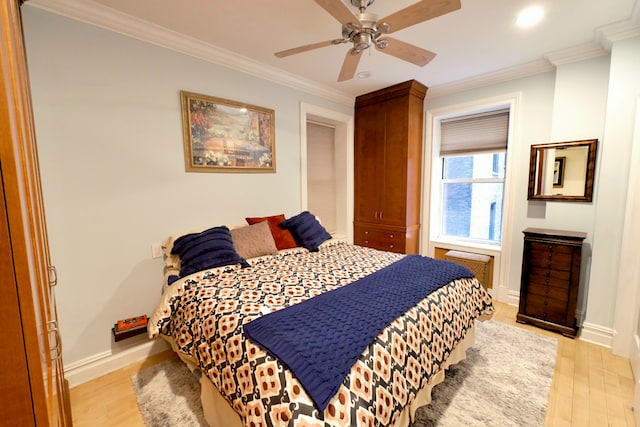 bedroom featuring light wood finished floors, baseboards, ornamental molding, and ceiling fan