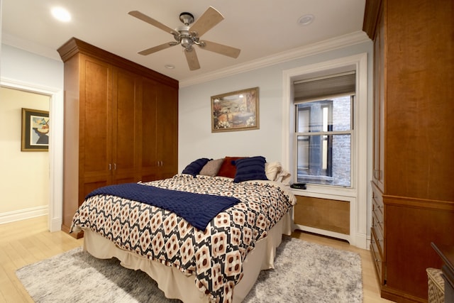 bedroom with ornamental molding, light wood-style floors, baseboards, and ceiling fan