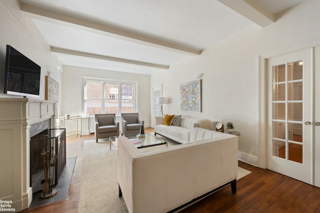 living room featuring beamed ceiling, wood finished floors, a high end fireplace, and baseboards