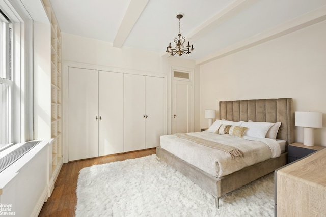 bedroom featuring a notable chandelier, a closet, beam ceiling, and wood finished floors