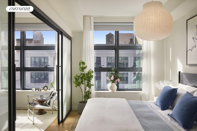 bedroom featuring multiple windows and wood finished floors