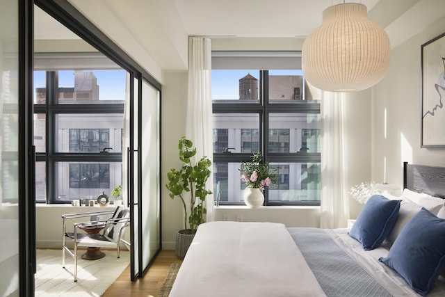 bedroom featuring multiple windows and wood finished floors