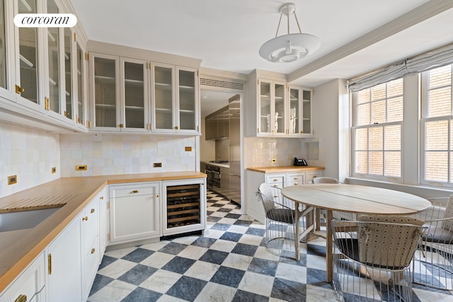 kitchen featuring wine cooler, light floors, backsplash, glass insert cabinets, and butcher block countertops