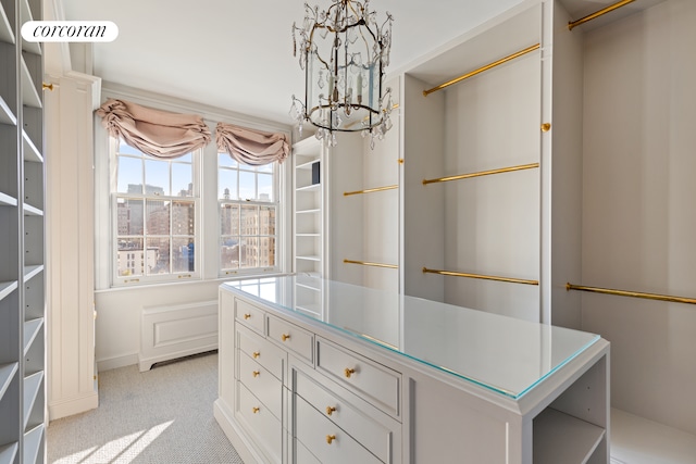 spacious closet with light carpet and an inviting chandelier