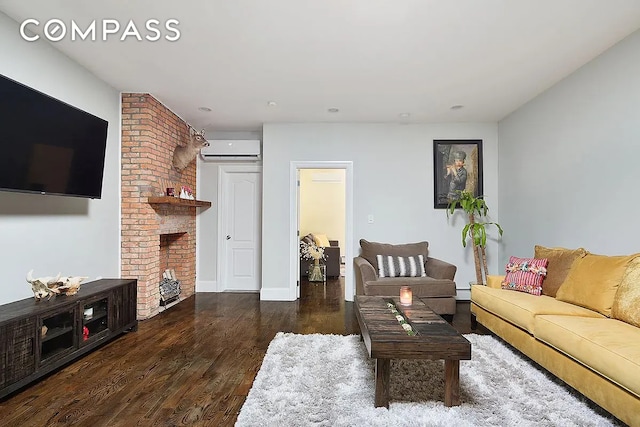 living area with a fireplace, an AC wall unit, baseboards, and wood finished floors