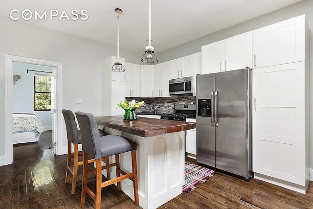 kitchen with backsplash, dark wood-style floors, butcher block counters, stainless steel appliances, and white cabinetry