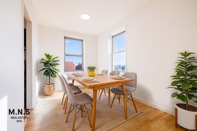 dining room with light wood-type flooring and baseboards