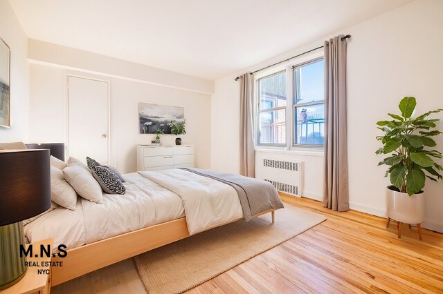 bedroom with wood finished floors and radiator