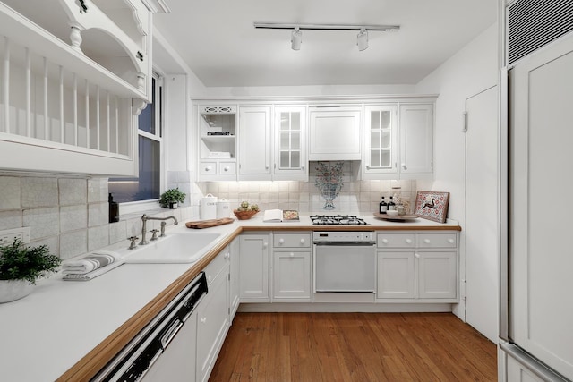 kitchen with track lighting, stainless steel gas stovetop, open shelves, a sink, and white cabinetry