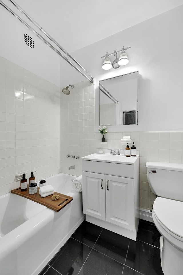 full bath featuring toilet, shower / bath combination, vanity, tile walls, and tile patterned floors