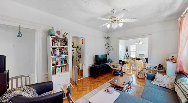 living room with ceiling fan and a textured ceiling