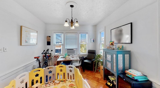 rec room featuring a notable chandelier, cooling unit, and a textured ceiling