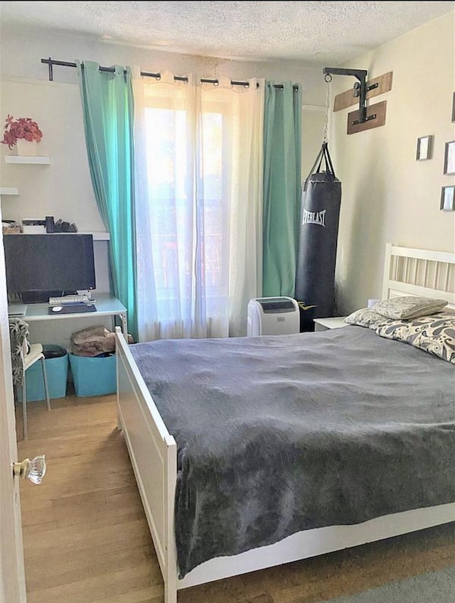 bedroom featuring a textured ceiling and wood finished floors