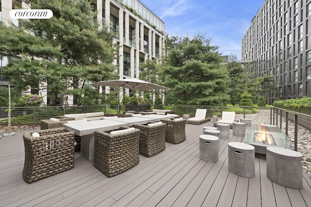 wooden terrace with an outdoor fire pit and outdoor dining area
