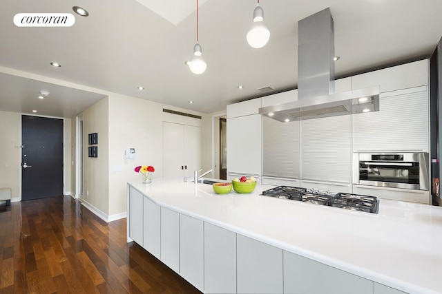 kitchen with visible vents, island range hood, dark wood finished floors, modern cabinets, and appliances with stainless steel finishes