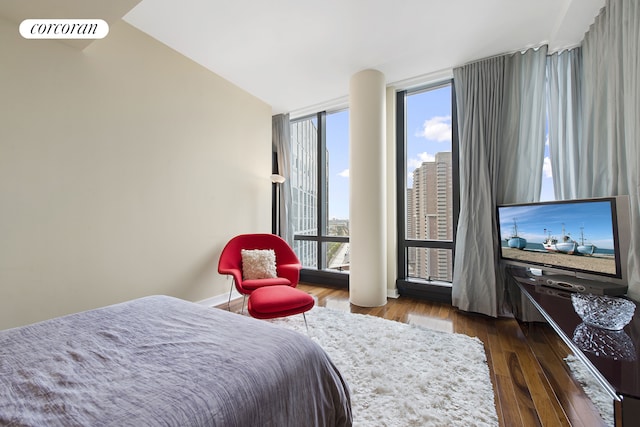 bedroom featuring wood-type flooring, baseboards, visible vents, and floor to ceiling windows