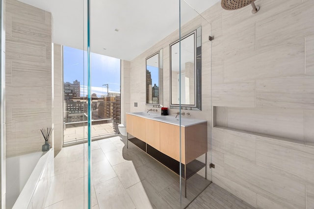 215 W 28th St Unit 14C, New York City, NY 10001 - bathroom featuring a view of city, double vanity, tile patterned flooring, expansive windows, and a shower