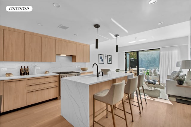 24 Huntington St, New York City, NY 11231 - kitchen with light brown cabinets, a breakfast bar, light wood-style floors, backsplash, and recessed lighting