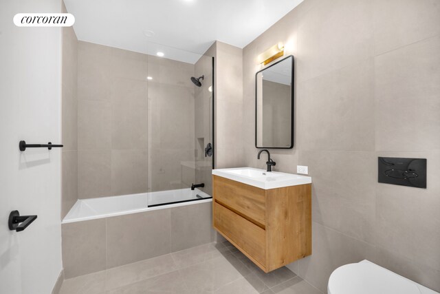 24 Huntington St, New York City, NY 11231 - bathroom with tiled shower / bath combo, vanity, tile patterned flooring, and tile walls