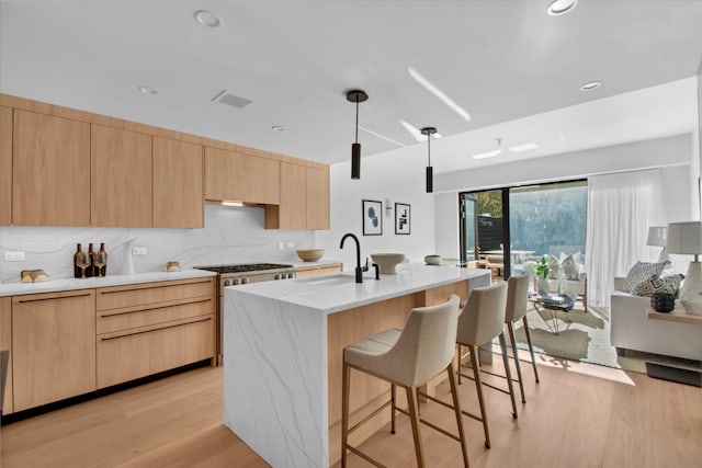 24 Huntington St, New York City, NY 11231 - kitchen featuring light brown cabinets, a breakfast bar, light wood-style floors, tasteful backsplash, and recessed lighting