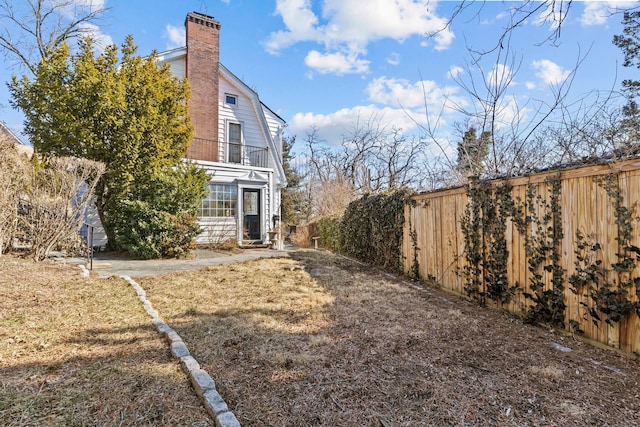 view of yard featuring a balcony and a fenced backyard