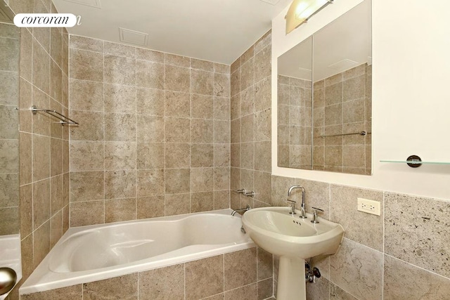 bathroom featuring tiled shower / bath combo and tile walls