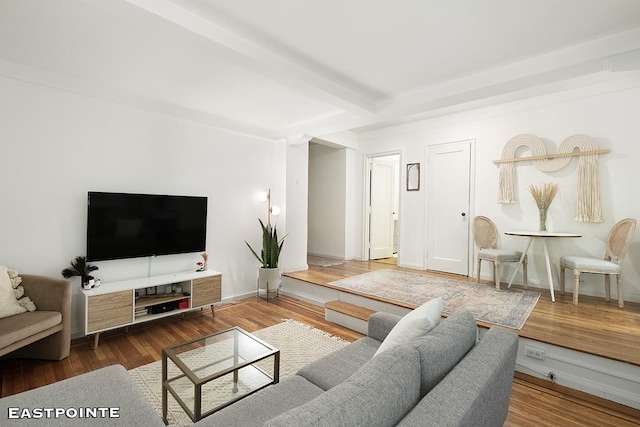 living area featuring beamed ceiling, wood finished floors, and baseboards