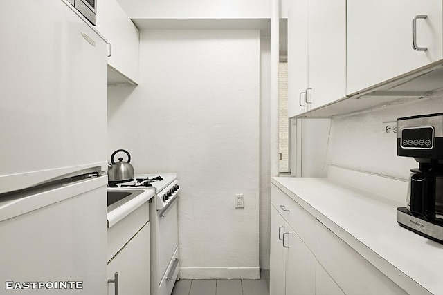 kitchen featuring white cabinets, white appliances, baseboards, and light countertops