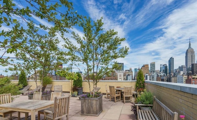 view of patio with outdoor dining space and a city view