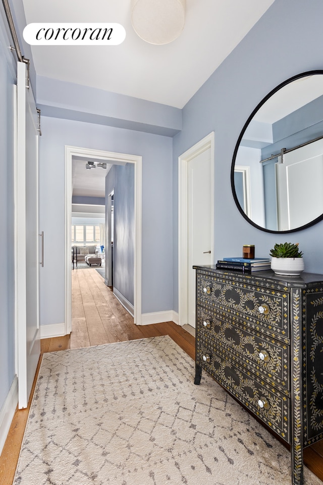 hall featuring wood finished floors and baseboards