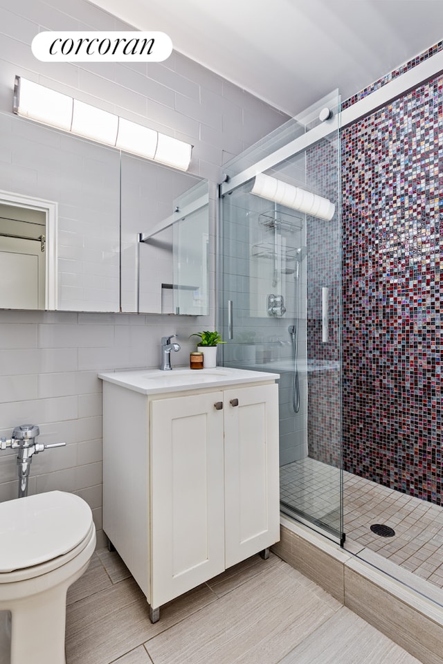 full bath with vanity, tile walls, toilet, and a stall shower