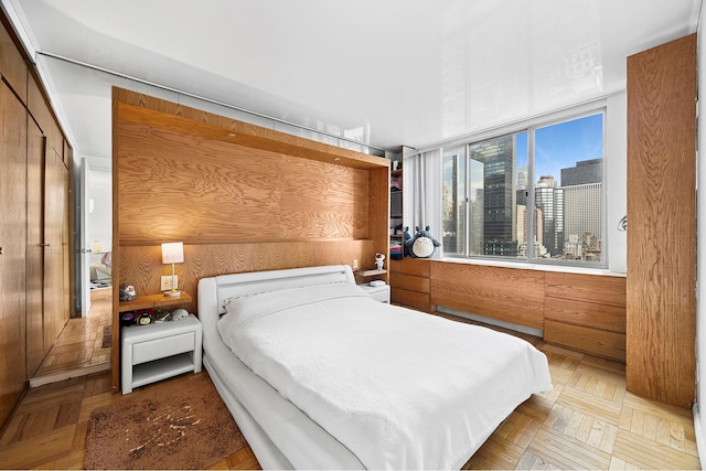 bedroom featuring a city view and wooden walls