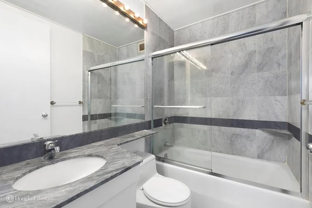 bathroom with vanity, toilet, visible vents, and bath / shower combo with glass door