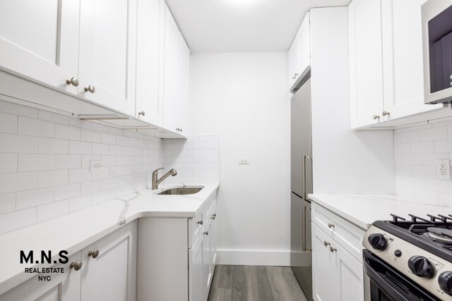 3855 Shore Pkwy Unit 3-H, New York City, NY 11235 - kitchen featuring white cabinets, dark wood-style flooring, a sink, baseboards, and backsplash