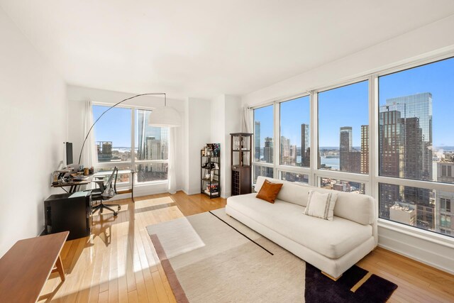 350 W 42nd St Unit 37H, New York City, NY 10036 - living area with a skyline view, an office area, and wood finished floors