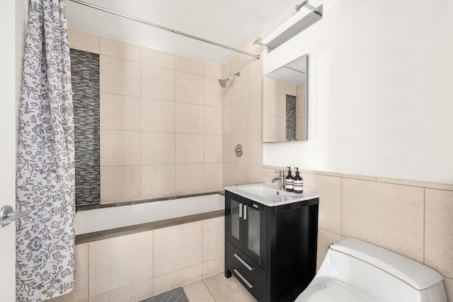 full bath featuring toilet, vanity, tile walls, and tiled shower / bath