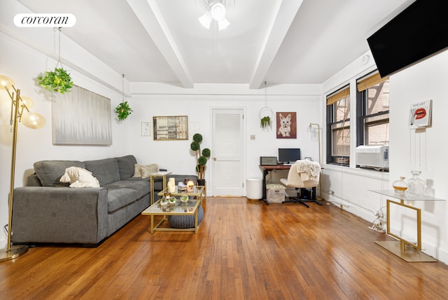 living area with wood-type flooring, visible vents, and beamed ceiling