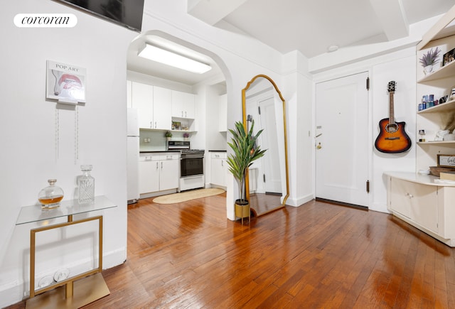 entryway with arched walkways, visible vents, and hardwood / wood-style flooring