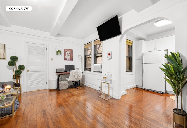 home office with arched walkways, cooling unit, visible vents, hardwood / wood-style floors, and beamed ceiling