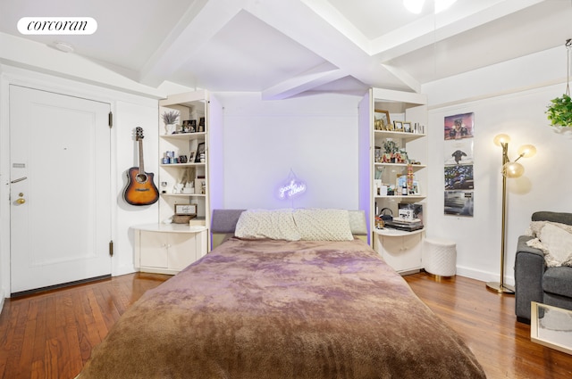 bedroom with beam ceiling, coffered ceiling, wood finished floors, and visible vents